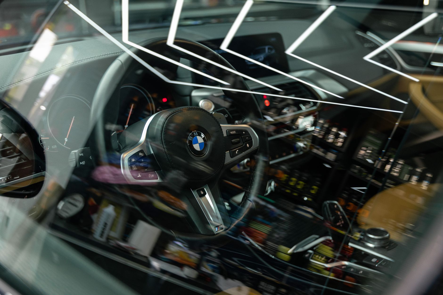Close-up view of a modern BMW car interior featuring a luxury steering wheel and dashboard.