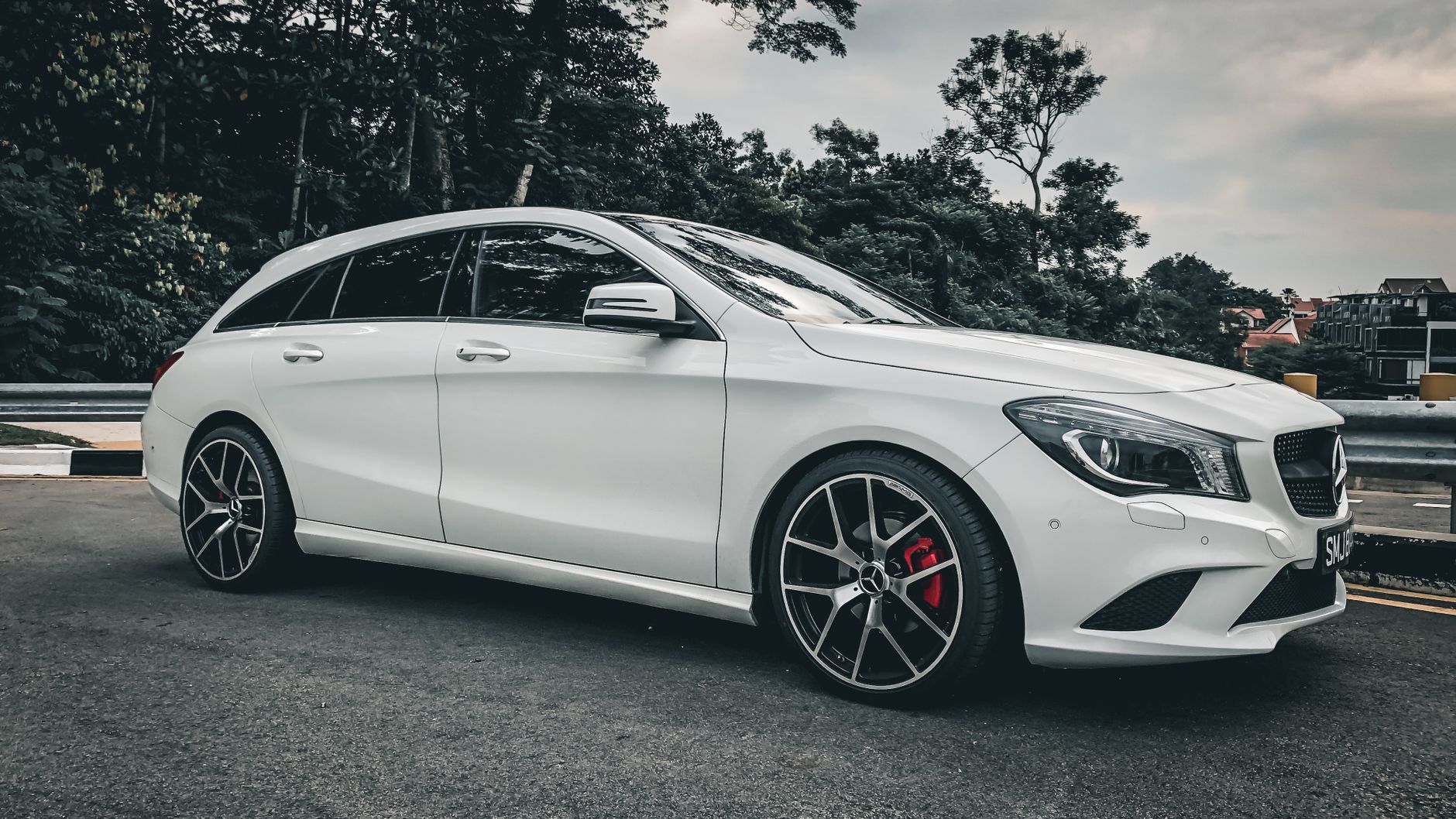 Sleek white Mercedes Benz parked in a Singapore urban setting, showcasing luxury design.