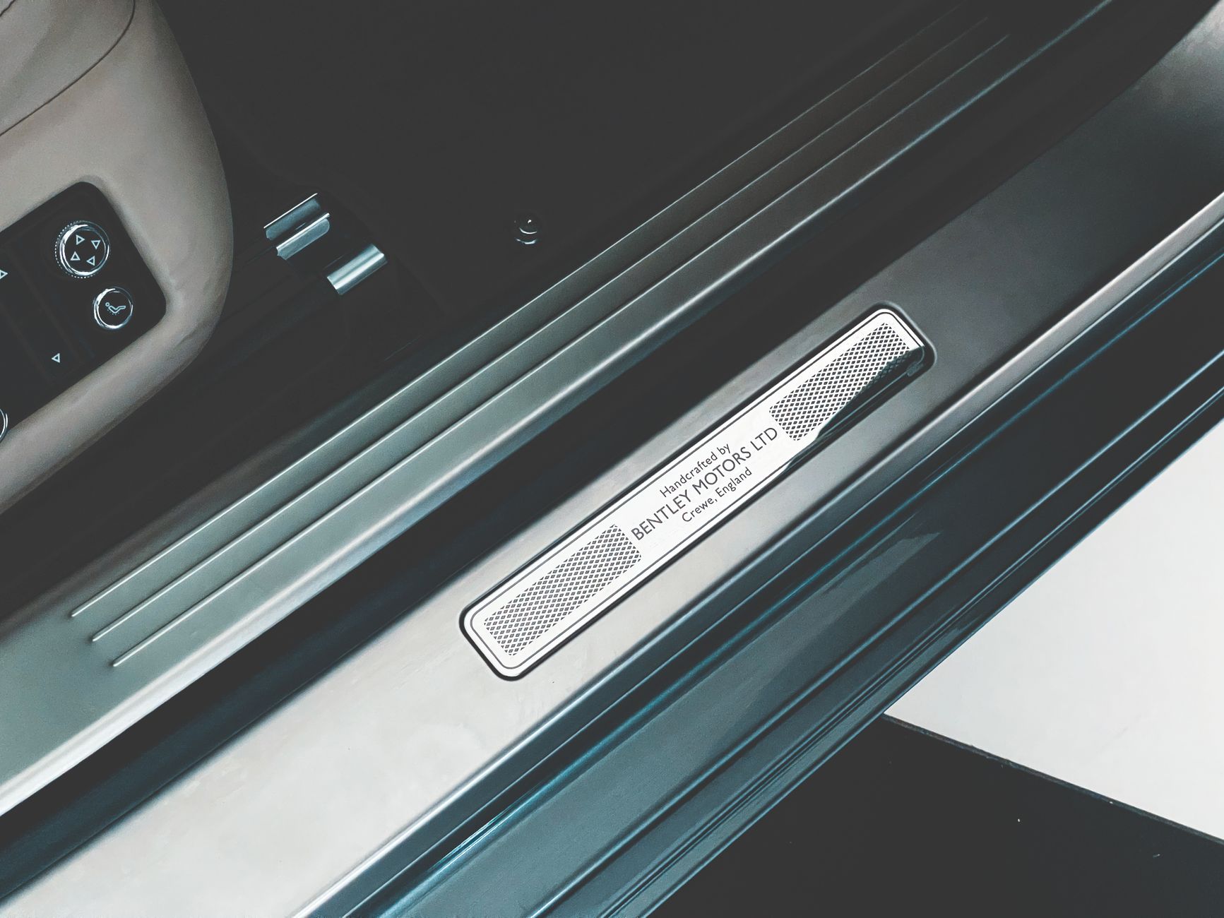 Close-up of a Bentley car door sill plate, showcasing luxury design detail.