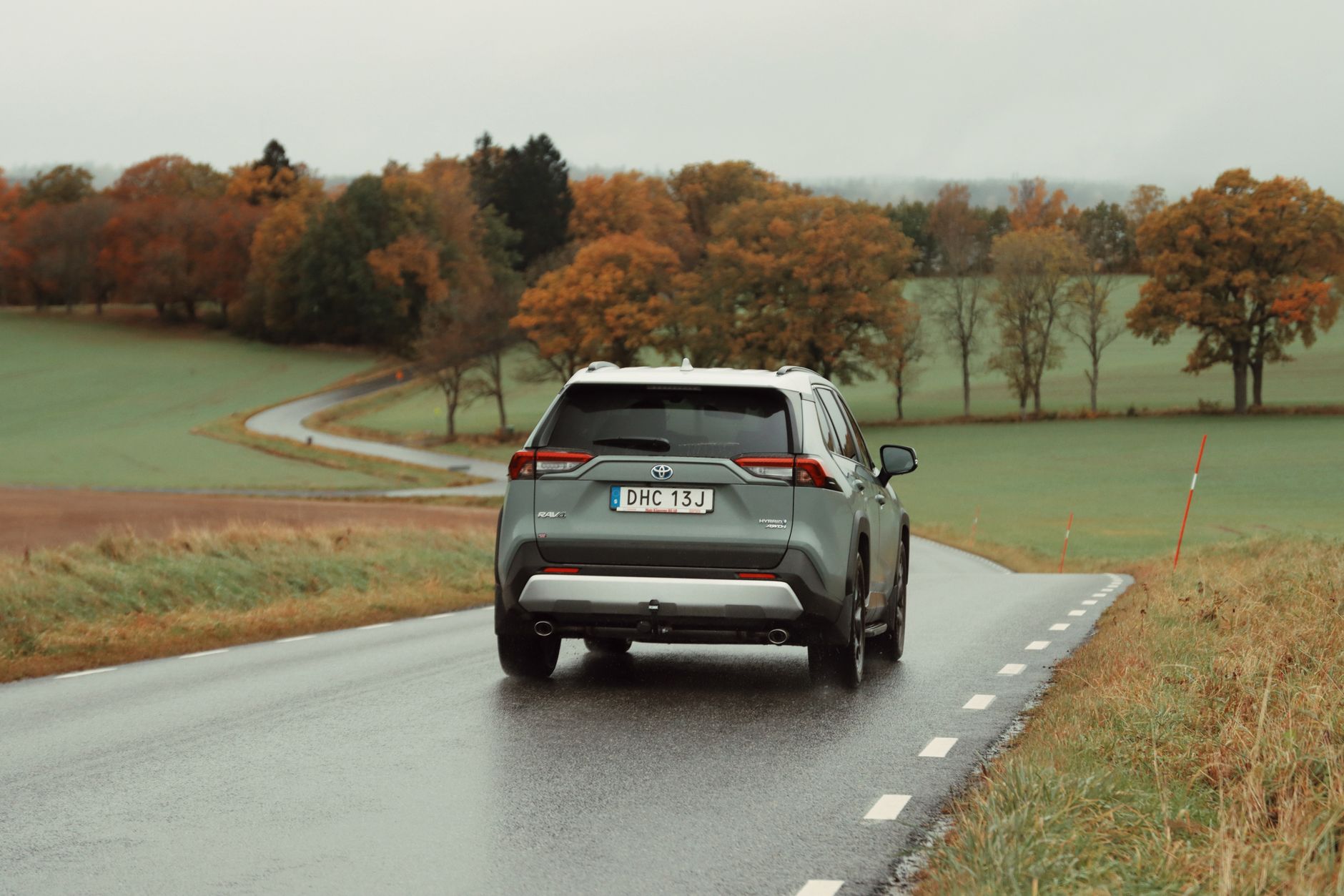 Back view of a Toyota SUV driving on a scenic road in Jönköping, Sweden.