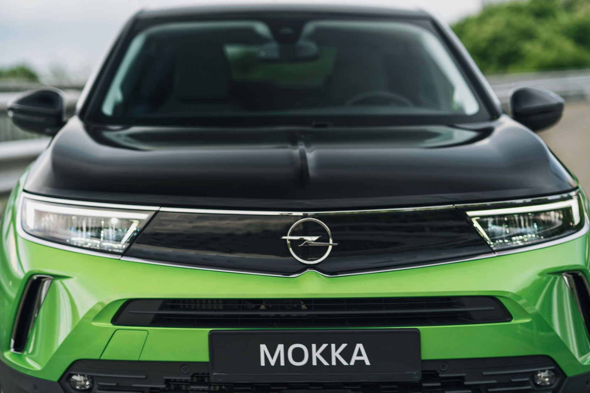 Close-up view of the front of a green Opel Mokka-e electric vehicle.