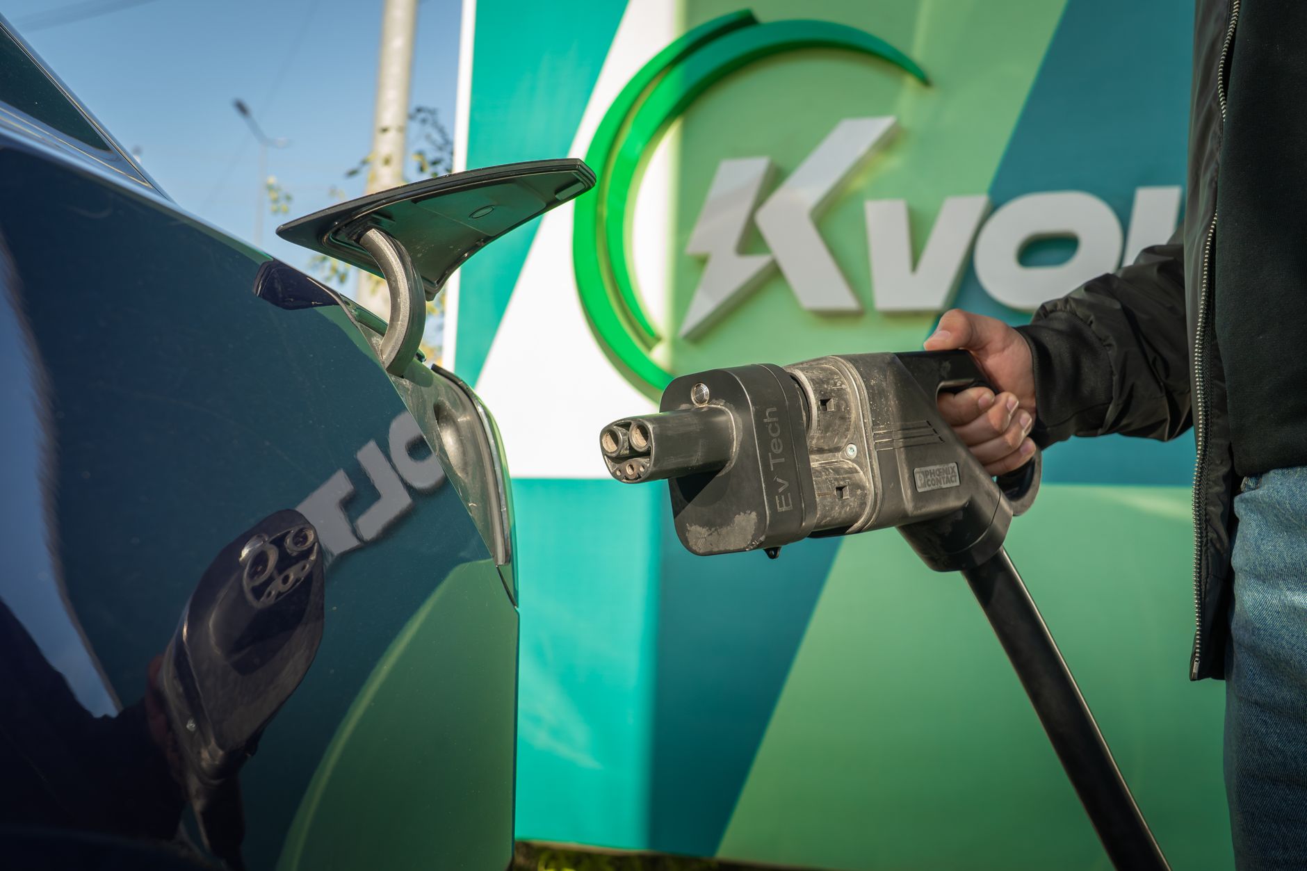 Close-up of an electric car being charged at a public station.
