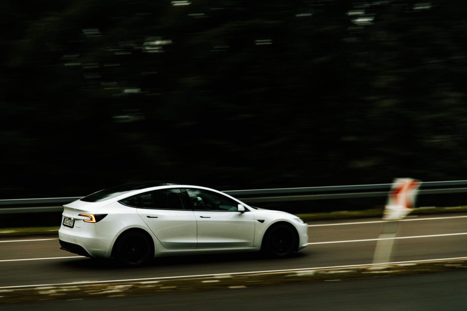 A modern electric car in motion on a highway, showcasing speed and innovation.