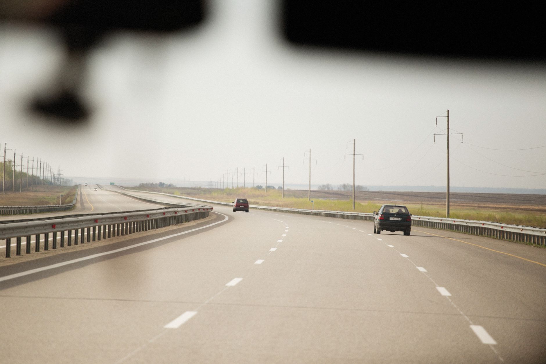 Expansive highway scene with cars and utility poles stretching into the distance.