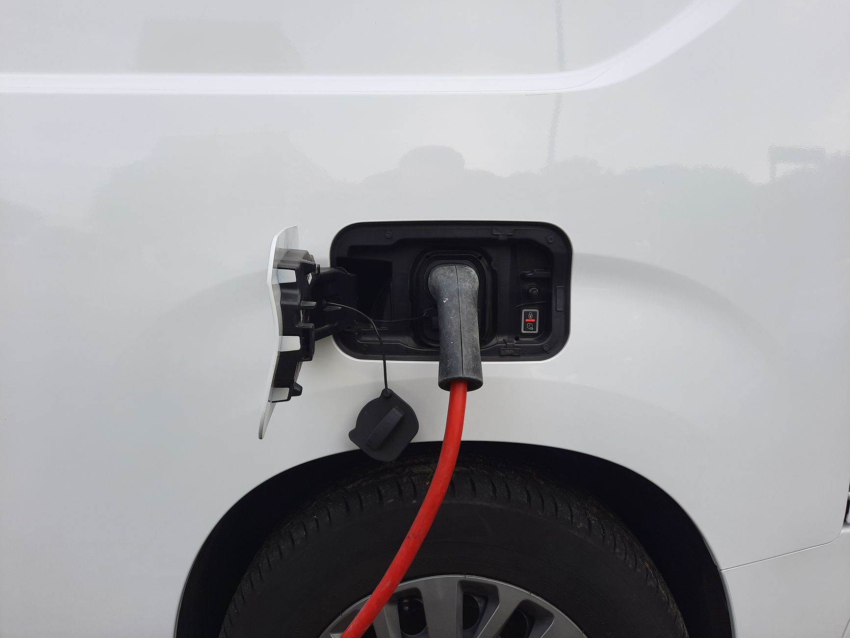 Close-up view of an electric vehicle charging port with a connected charging cable.
