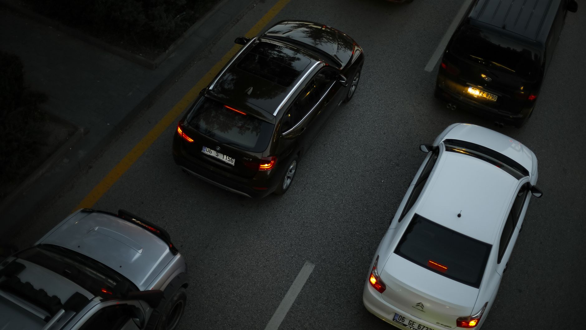 Aerial shot showing multiple cars driving on a city road during the evening, illustrating urban traffic.