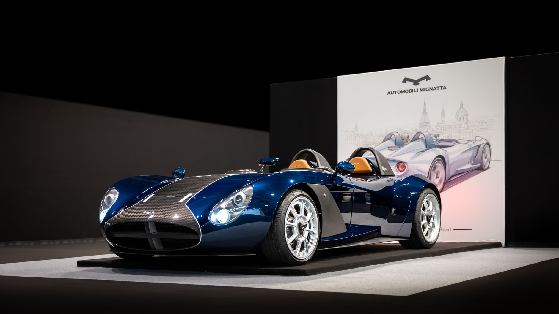 A stunning blue sports car displayed at an indoor auto show, showcasing modern design.