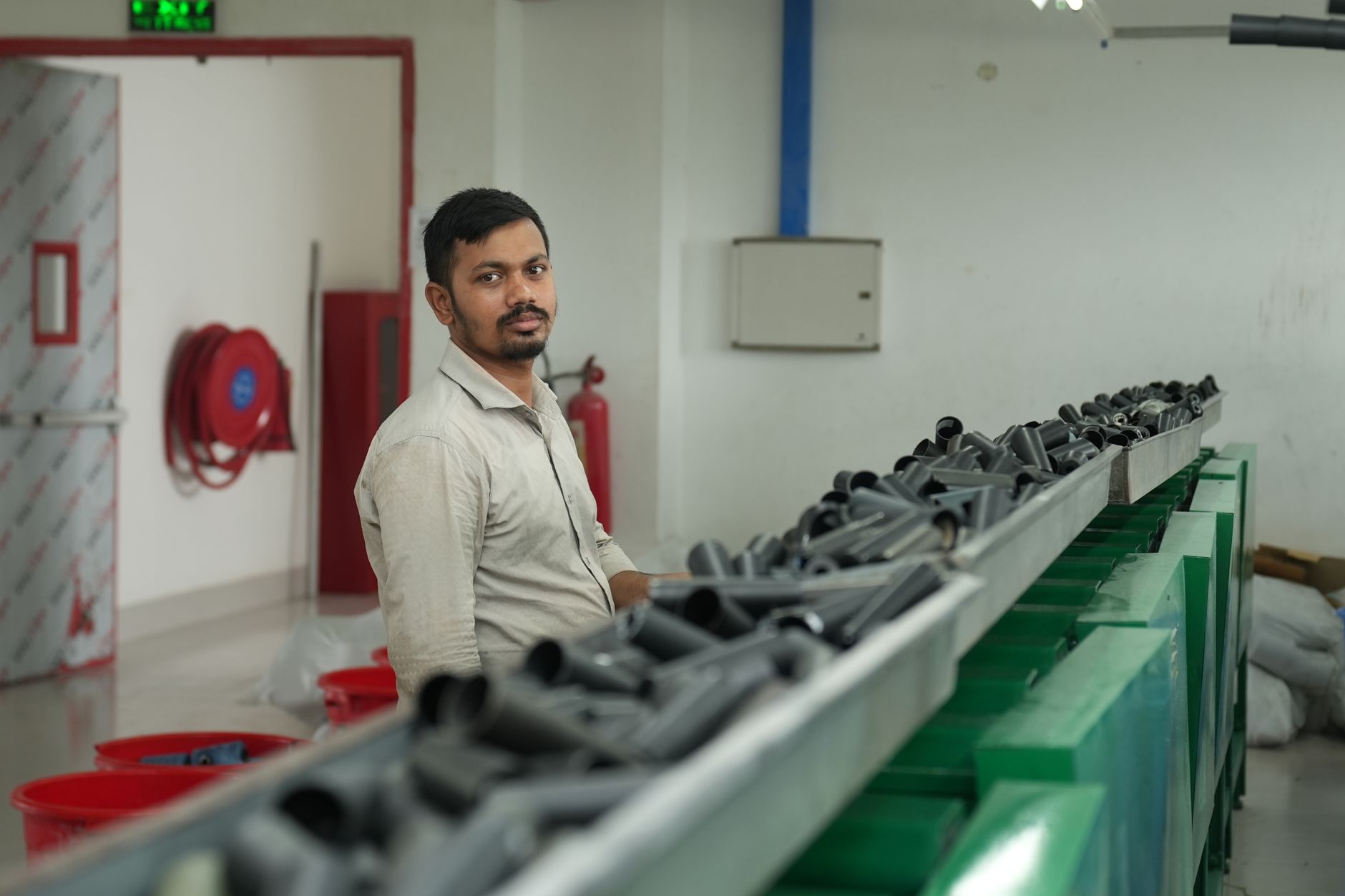 A factory worker oversees the operation of a conveyor belt transporting materials.