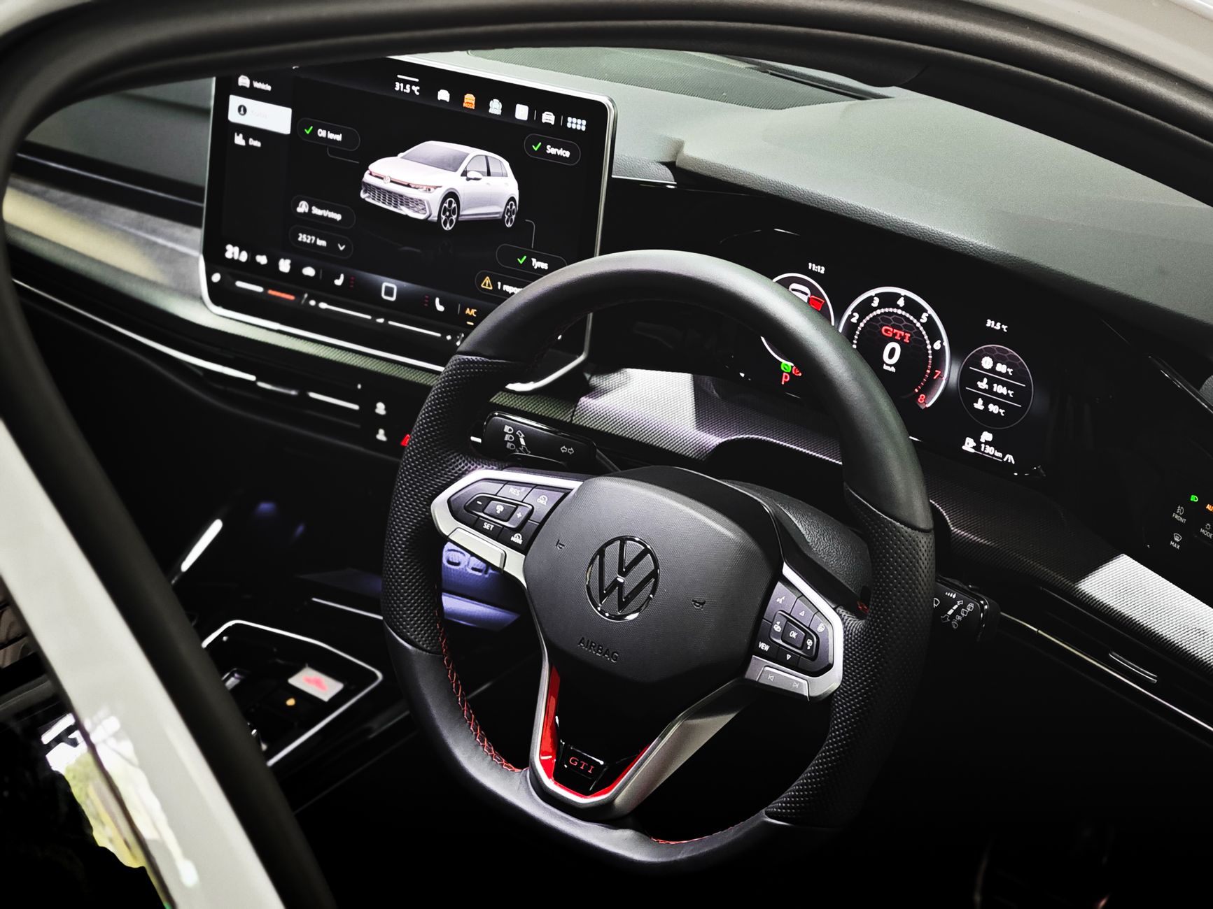 Stylish car interior showcasing modern high-tech dashboard and steering wheel.