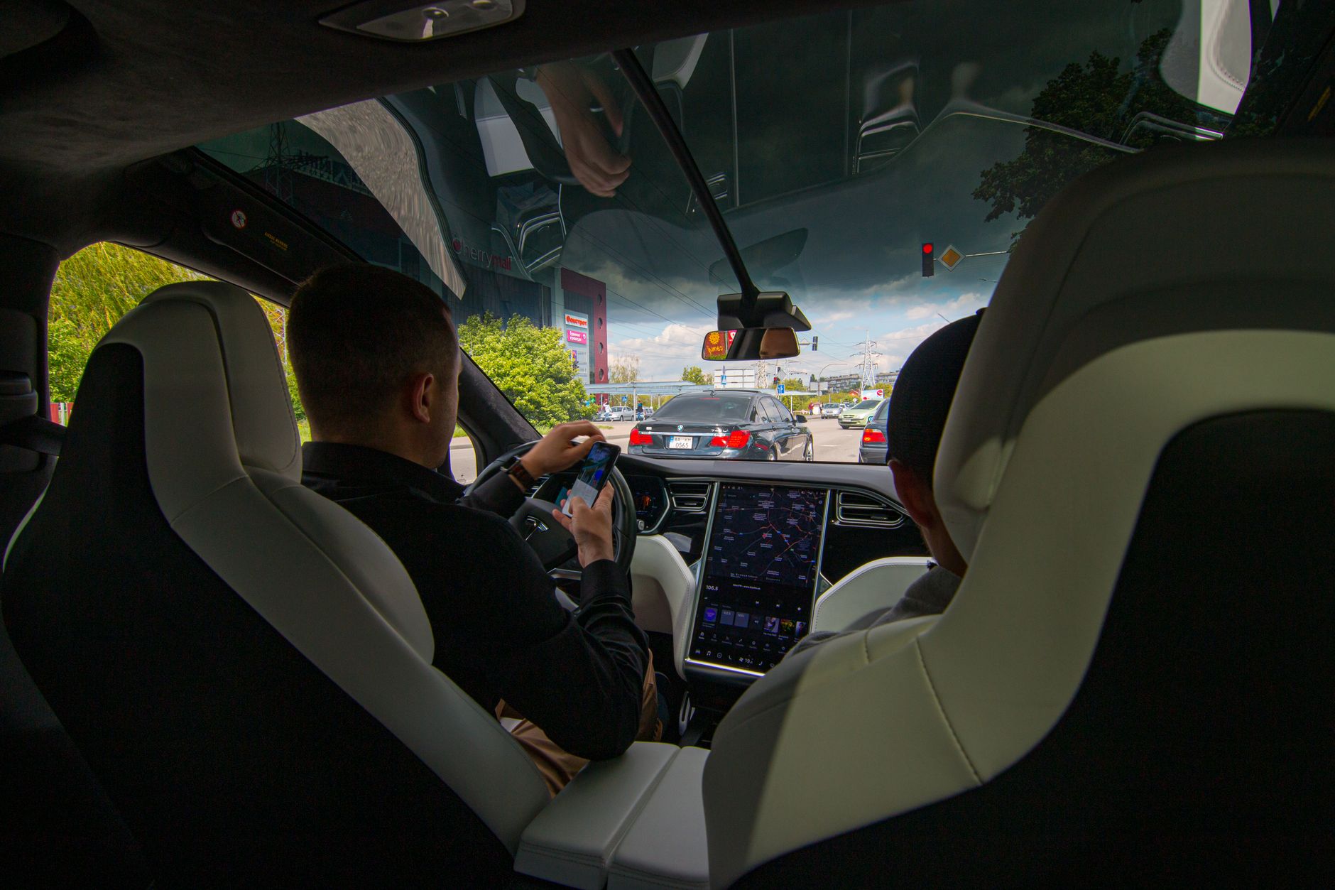 Inside a Tesla vehicle in city traffic, showcasing modern technology and urban driving.