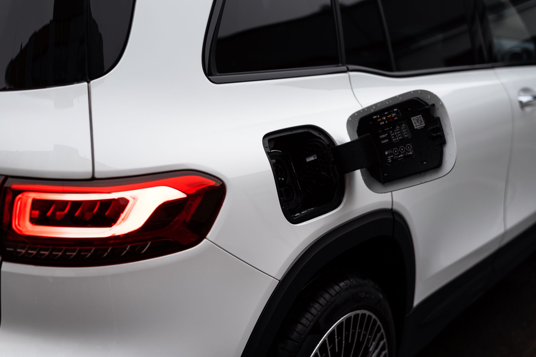 Close-up of a modern electric vehicle with an open charging port, showcasing clean design.