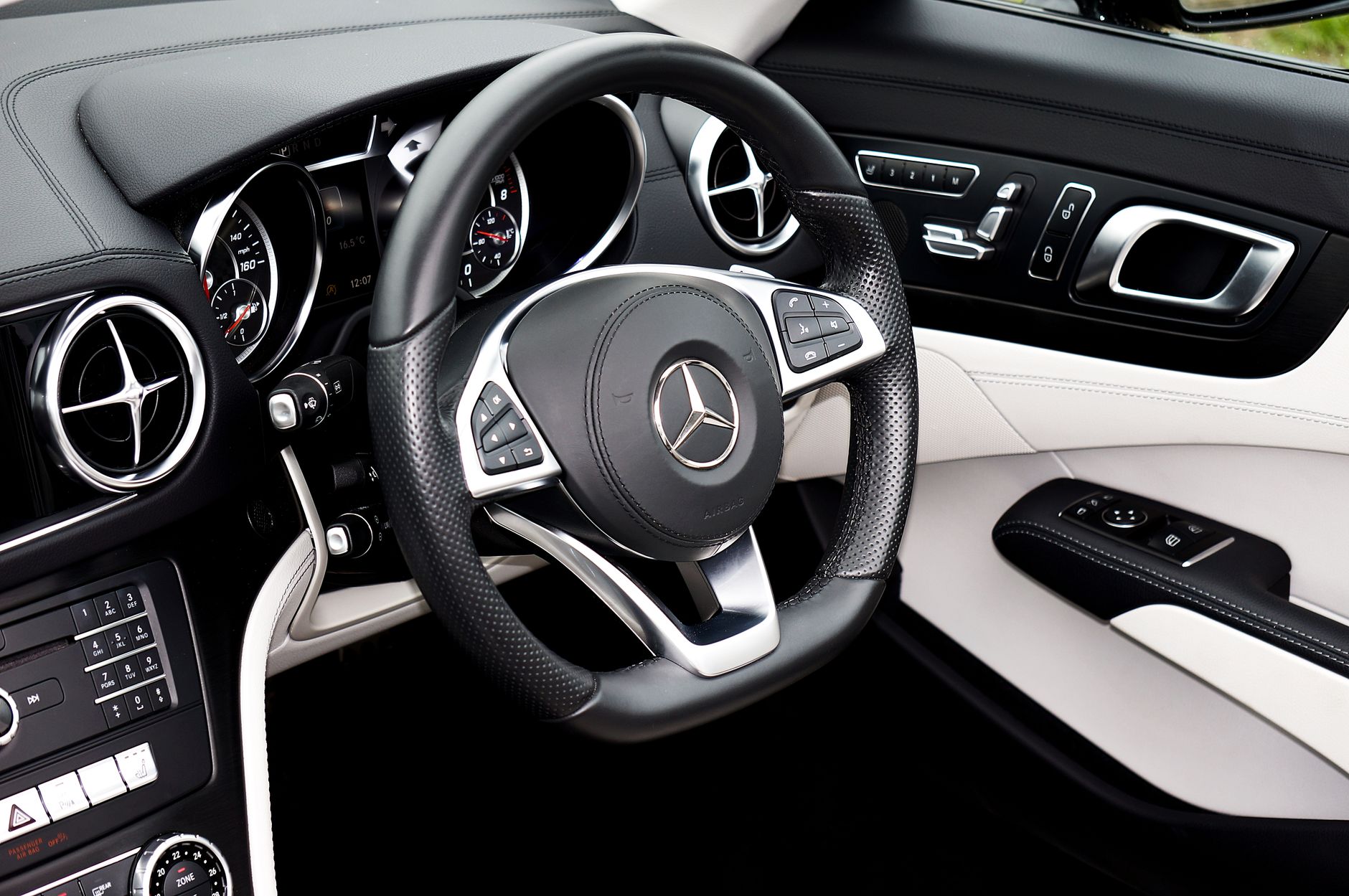Explore the elegance of a Mercedes interior featuring a sleek steering wheel and modern dashboard.